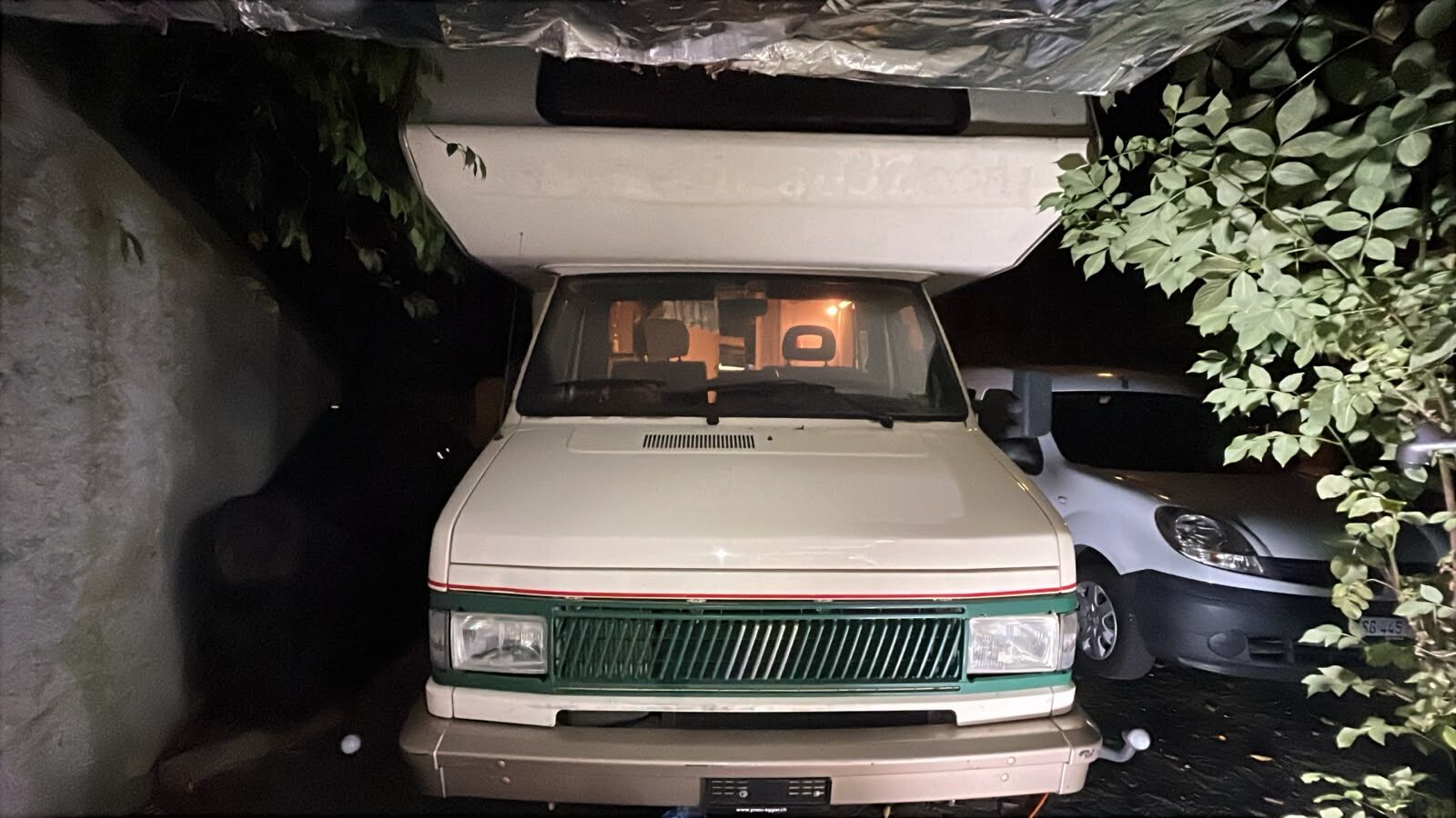 Wohnmobil nachts in der Einfahrt, Innenlicht an
